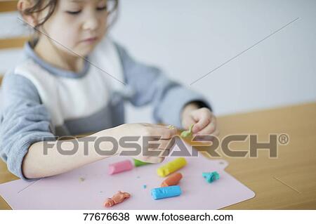 Cute Japanese kid playing with clay View Large Photo Image Stock Photo - Cute Japanese kid playing with clay. Fotosearch