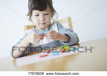 Cute Japanese kid playing with clay View Large Photo Image Stock Photo - Cute Japanese kid playing with clay. Fotosearch