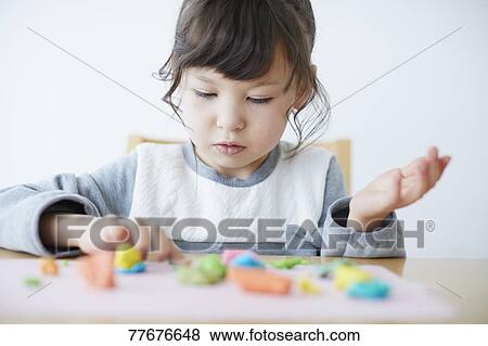 Cute Japanese kid playing with clay View Large Photo Image Stock Photo - Cute Japanese kid playing with clay. Fotosearch