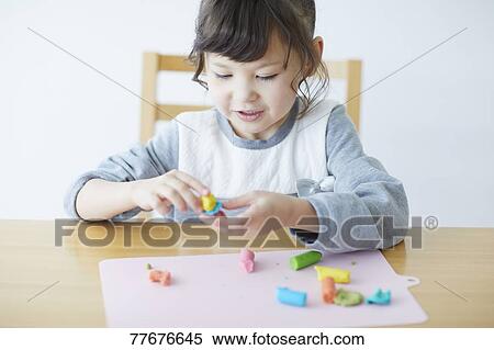 Cute Japanese kid playing with clay View Large Photo Image Stock Photography - Cute Japanese kid playing with clay. Fotosearch