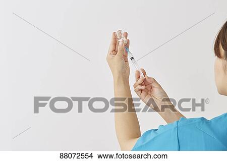 Doctor preparing injection View Large Photo Image Picture - Doctor preparing injection. Fotosearch