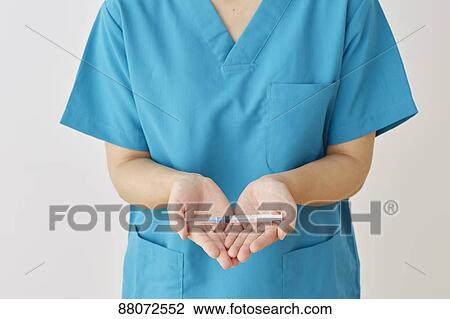 Stock Image - Doctor preparing injection. Fotosearch