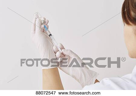 Stock Photo - Doctor preparing injection. Fotosearch