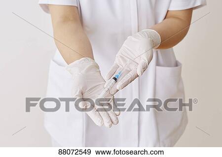 Stock Photo - Doctor preparing injection. Fotosearch