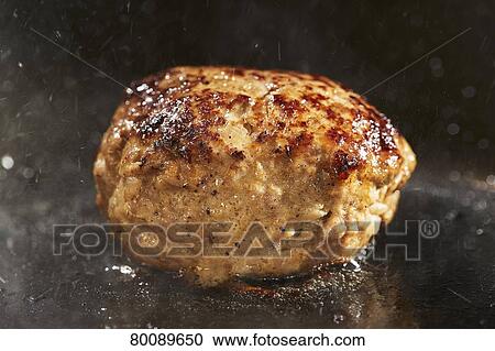 Stock Image - Grilling burg steak. Fotosearch