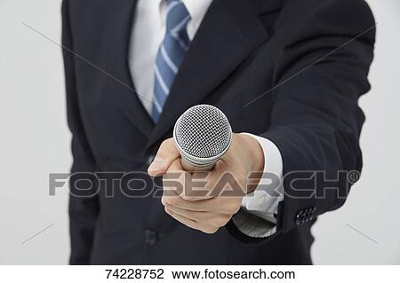 Stock Image - Hand holding microphone. Fotosearch
