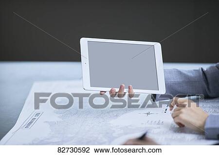 Hand holding tablet in the office View Large Photo Image Stock Image - Hand holding tablet in the office. Fotosearch