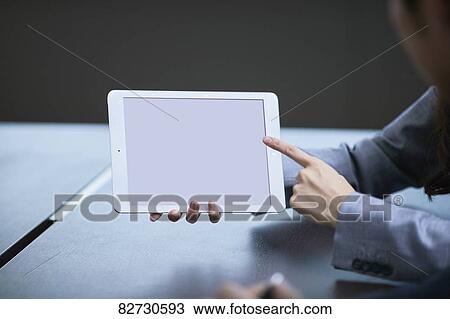 Stock Image - Hand holding tablet in the office. Fotosearch