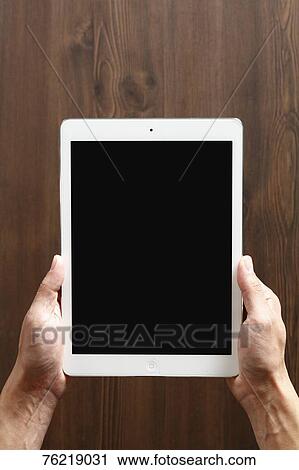 Stock Image - Hands holding tablet. Fotosearch