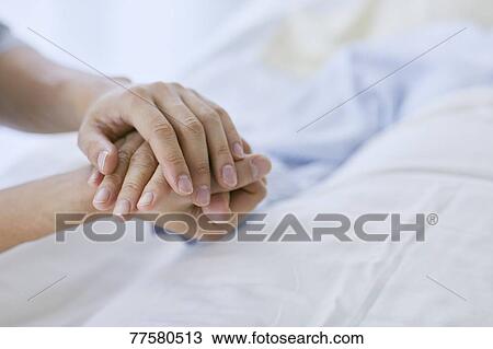 Holding hand of patient in bed View Large Photo Image Stock Image - Holding hand of patient in bed. Fotosearch
