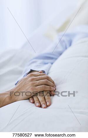 Stock Photo - Holding hand of patient in bed. Fotosearch