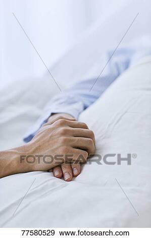 Stock Photo - Holding hand of patient in bed. Fotosearch
