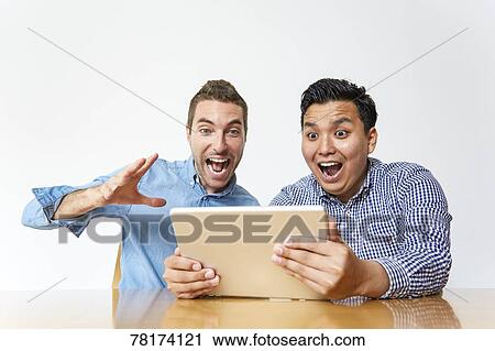 International friends enjoying content on a tablet View Large Photo Image Stock Image - International friends enjoying content on a tablet. Fotosearch