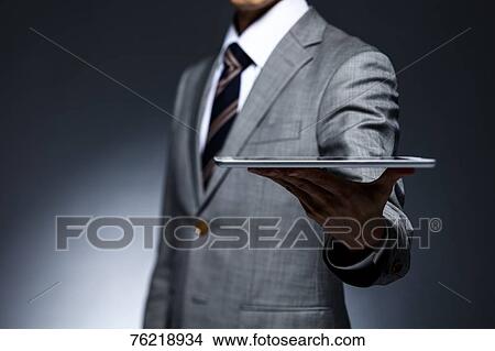 Picture - Japanese businessman against grey background. Fotosearch