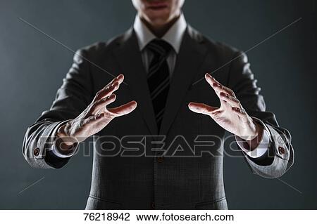 Stock Image - Japanese businessman against grey background. Fotosearch