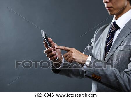 Japanese businessman against grey background View Large Photo Image Stock Photograph - Japanese businessman against grey background. Fotosearch