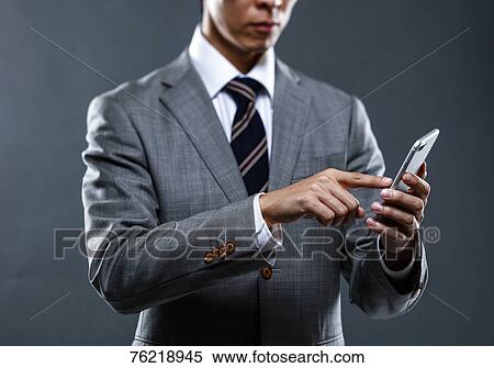 Japanese businessman against grey background View Large Photo Image Stock Photography - Japanese businessman against grey background. Fotosearch
