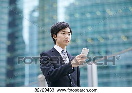 Stock Image - Japanese businessman downtown Tokyo. Fotosearch