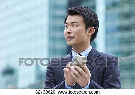 Stock Image - Japanese businessman downtown Tokyo. Fotosearch