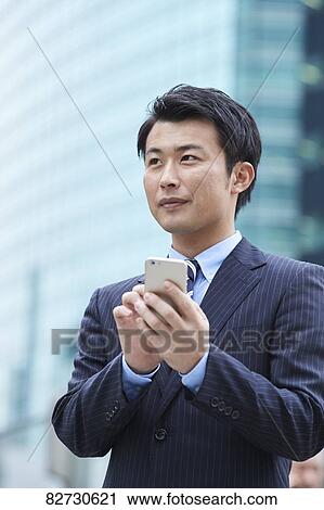 Stock Image - Japanese businessman downtown Tokyo. Fotosearch