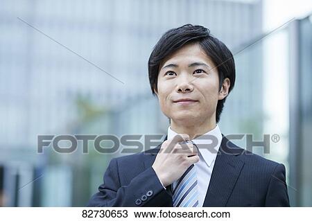Stock Image - Japanese businessman downtown Tokyo. Fotosearch
