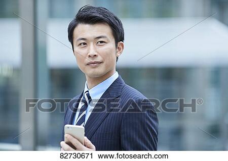 Stock Image - Japanese businessman downtown Tokyo. Fotosearch