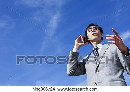 Japanese businessman on the phone downtown Tokyo, Japan View Large Photo Image Picture - Japanese businessman on the phone downtown Tokyo, Japan. Fotosearch