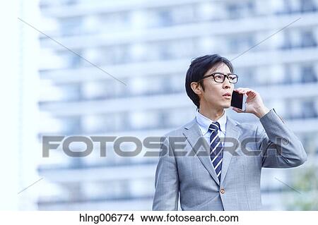 Japanese businessman on the phone downtown Tokyo, Japan View Large Photo Image Picture - Japanese businessman on the phone downtown Tokyo, Japan. Fotosearch