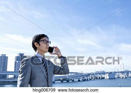 Japanese businessman on the phone downtown Tokyo, Japan View Large Photo Image Stock Photo - Japanese businessman on the phone downtown Tokyo, Japan. Fotosearch