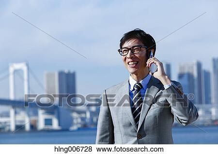 Stock Photo - Japanese businessman on the phone downtown Tokyo, Japan. Fotosearch