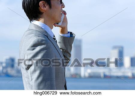 Stock Photo - Japanese businessman on the phone downtown Tokyo, Japan. Fotosearch