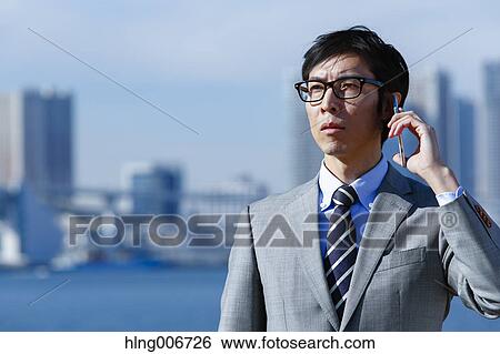 Stock Photograph - Japanese businessman on the phone downtown Tokyo, Japan. Fotosearch