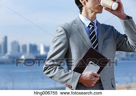 Stock Photography - Japanese businessman with coffee downtown Tokyo, Japan. Fotosearch
