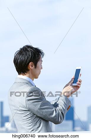 Japanese businessman with smartphone downtown Tokyo, Japan View Large Photo Image Stock Image - Japanese businessman with smartphone downtown Tokyo, Japan. Fotosearch
