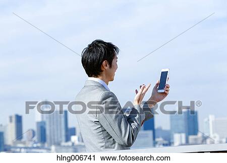 Japanese businessman with smartphone downtown Tokyo, Japan View Large Photo Image Stock Image - Japanese businessman with smartphone downtown Tokyo, Japan. Fotosearch