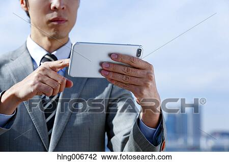 Japanese businessman with smartphone downtown Tokyo, Japan View Large Photo Image Stock Image - Japanese businessman with smartphone downtown Tokyo, Japan. Fotosearch