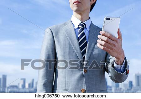 Japanese businessman with smartphone downtown Tokyo, Japan View Large Photo Image Stock Image - Japanese businessman with smartphone downtown Tokyo, Japan. Fotosearch