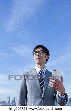 Japanese businessman with smartphone downtown Tokyo, Japan View Large Photo Image Stock Image - Japanese businessman with smartphone downtown Tokyo, Japan. Fotosearch