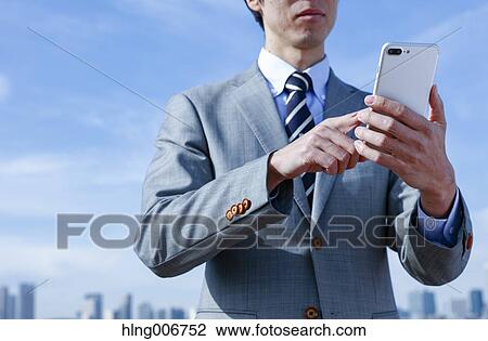 Japanese businessman with smartphone downtown Tokyo, Japan View Large Photo Image Stock Image - Japanese businessman with smartphone downtown Tokyo, Japan. Fotosearch