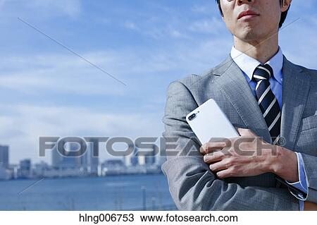 Japanese businessman with smartphone downtown Tokyo, Japan View Large Photo Image Stock Image - Japanese businessman with smartphone downtown Tokyo, Japan. Fotosearch