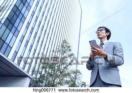 Japanese businessman with smartphone downtown Tokyo, Japan View Large Photo Image Stock Image - Japanese businessman with smartphone downtown Tokyo, Japan. Fotosearch