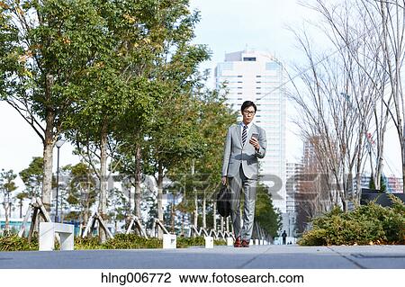 Japanese businessman with smartphone downtown Tokyo, Japan View Large Photo Image Stock Image - Japanese businessman with smartphone downtown Tokyo, Japan. Fotosearch