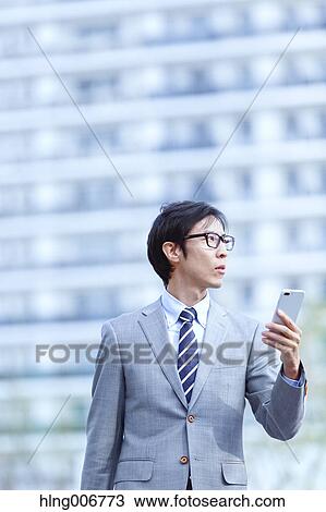 Japanese businessman with smartphone downtown Tokyo, Japan View Large Photo Image Stock Image - Japanese businessman with smartphone downtown Tokyo, Japan. Fotosearch