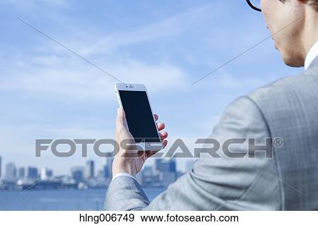 Japanese businessman with smartphone downtown Tokyo, Japan View Large Photo Image Stock Photo - Japanese businessman with smartphone downtown Tokyo, Japan. Fotosearch