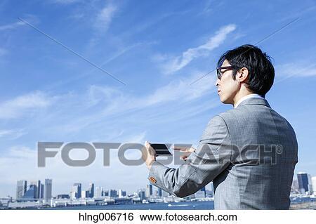 Japanese businessman with smartphone downtown Tokyo, Japan View Large Photo Image Stock Photograph - Japanese businessman with smartphone downtown Tokyo, Japan. Fotosearch