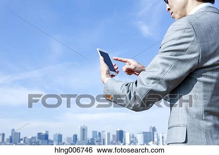Japanese businessman with smartphone downtown Tokyo, Japan View Large Photo Image Stock Photograph - Japanese businessman with smartphone downtown Tokyo, Japan. Fotosearch