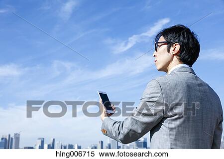 Japanese businessman with smartphone downtown Tokyo, Japan View Large Photo Image Stock Photography - Japanese businessman with smartphone downtown Tokyo, Japan. Fotosearch