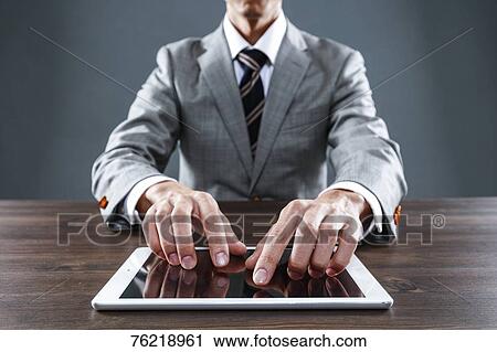 Stock Image - Japanese businessman working at desk. Fotosearch