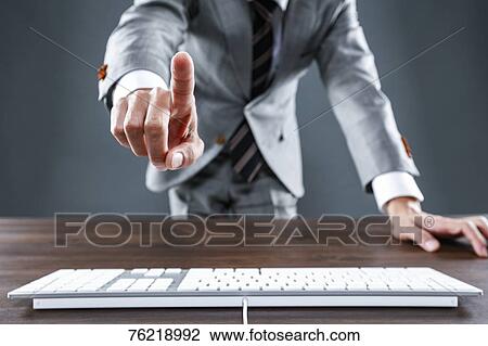 Stock Image - Japanese businessman working at desk. Fotosearch