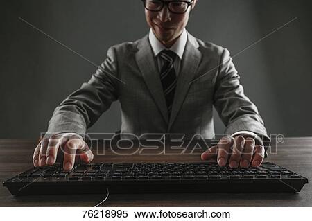 Stock Photography - Japanese businessman working at desk. Fotosearch